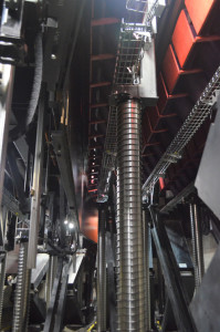 Closeup view of the lift columns, viewed from the end of a seating row (at machinery level). Two rows of seats in storage position (flipped upside-down) can be clearly seen at the top of the image. H-E-B Performance Hall at Tobin Center. (Photo by Paul Sanow ASTC).